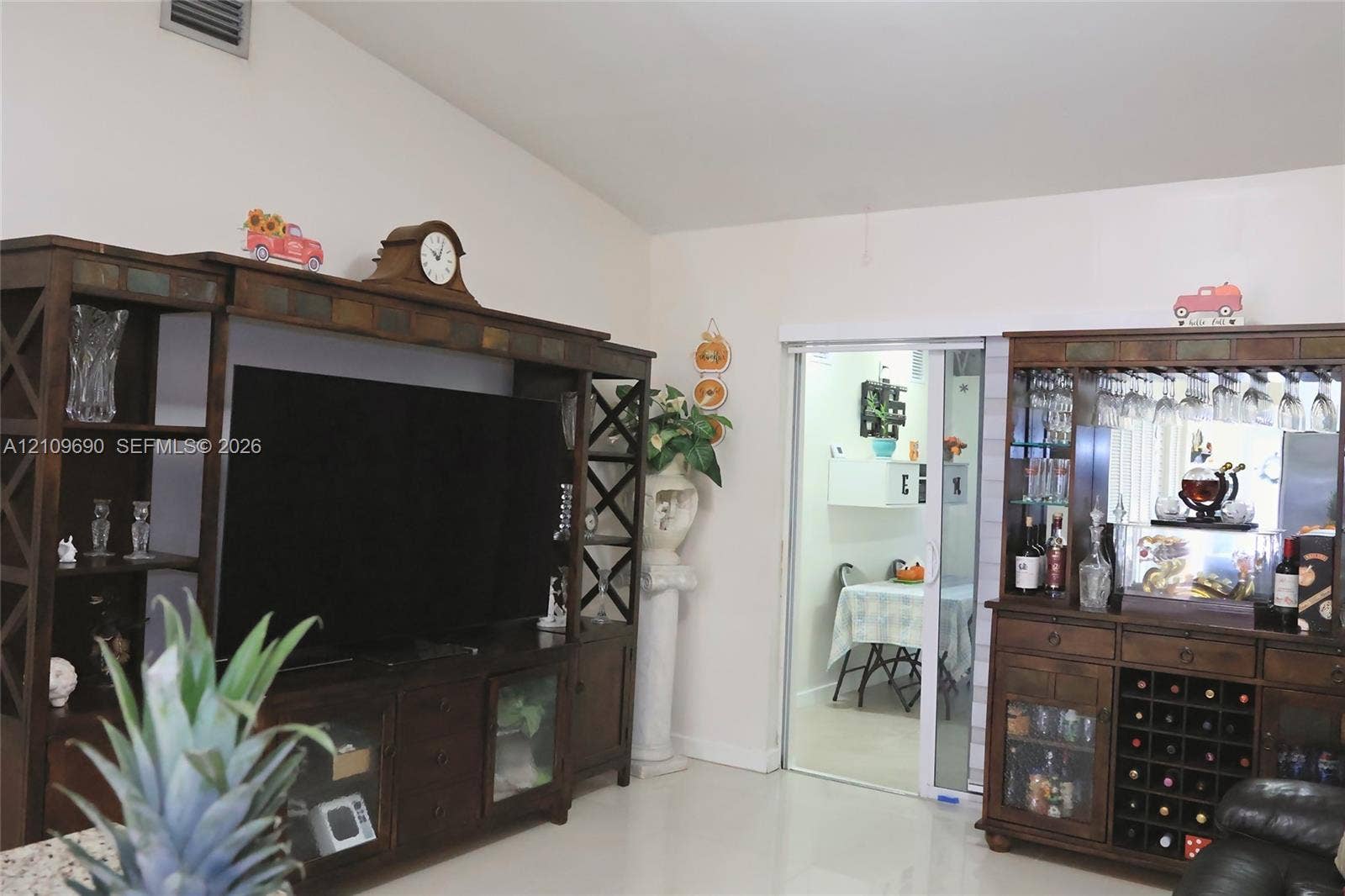 Vaulted ceiling and sliding glass door leading to a separate room