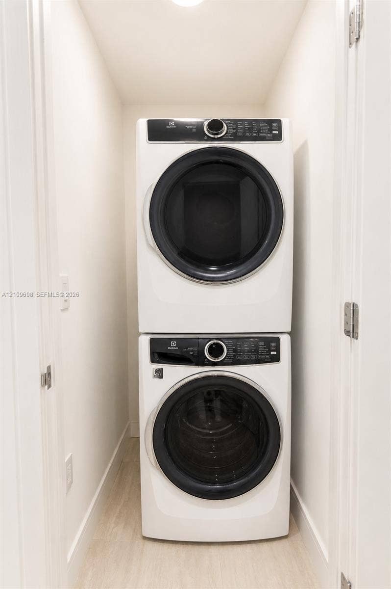 2411 Laguna Circle, #810, North Miami, FL 33181 Laundry closet featuring a white, stackable front-loading washer and dryer set