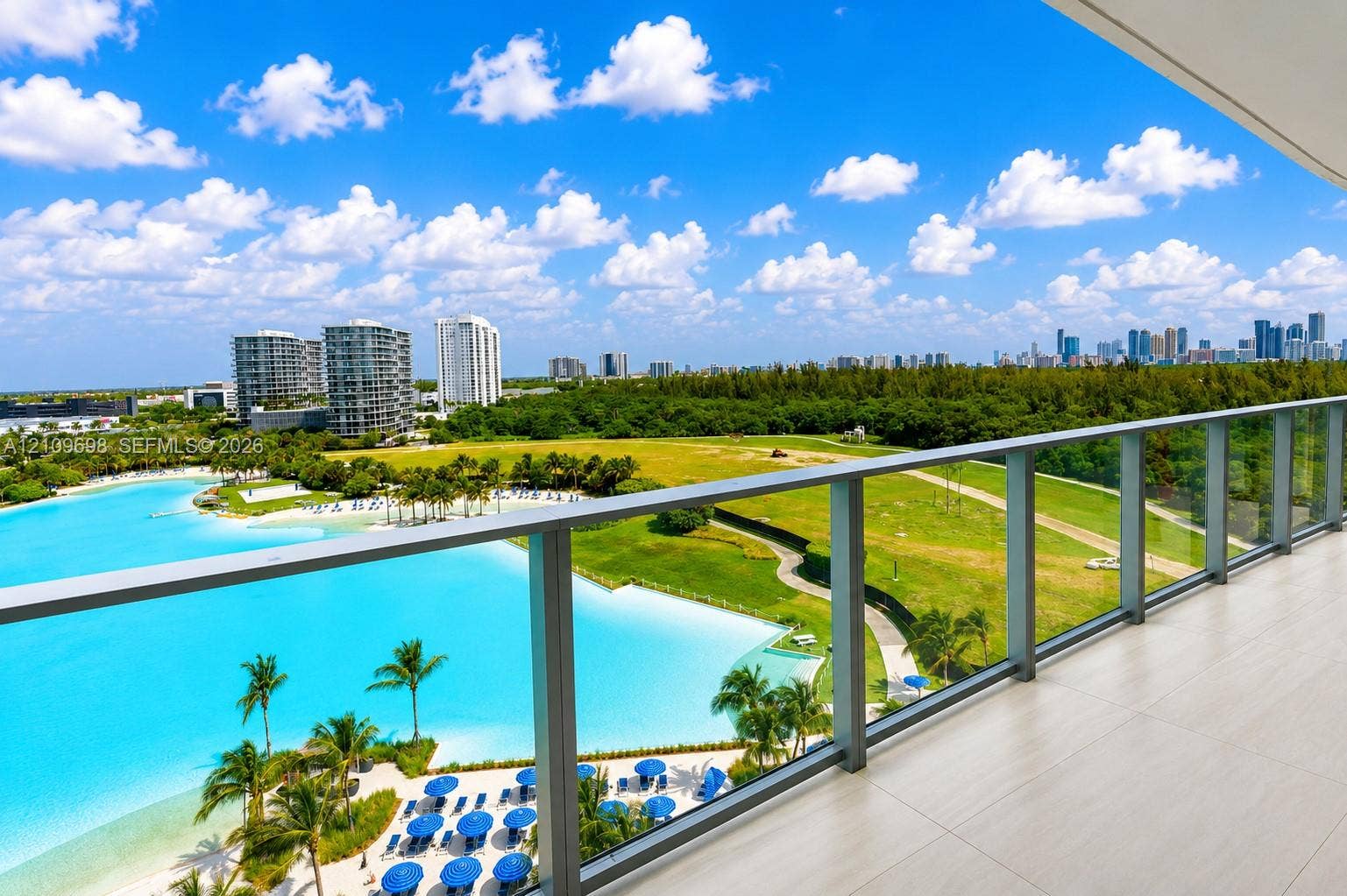 2411 Laguna Circle, #810, North Miami, FL 33181 Covered balcony featuring large-format porcelain tile flooring and a glass-paneled railing with metal framing