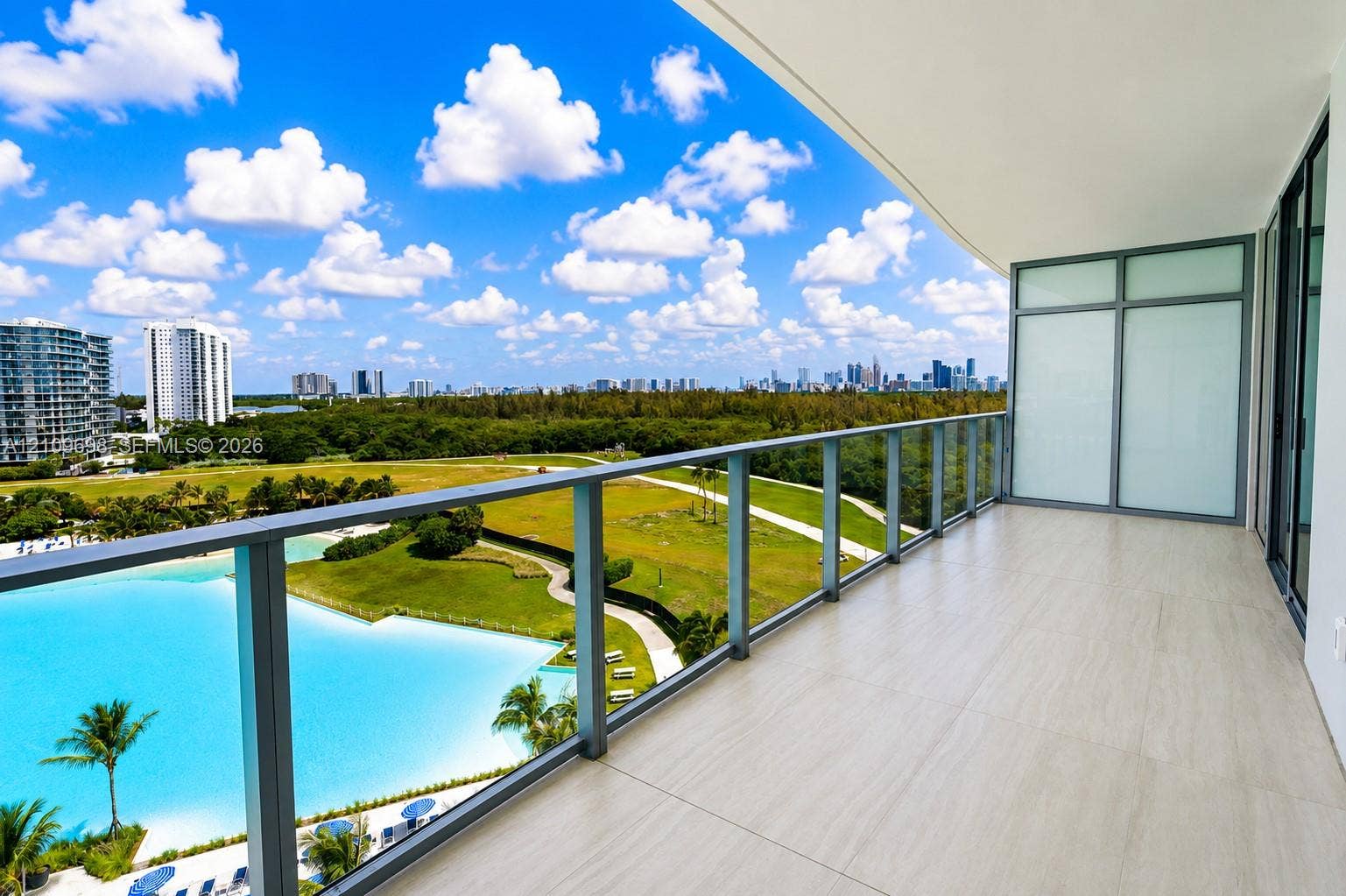 2411 Laguna Circle, #810, North Miami, FL 33181 Covered balcony featuring neutral large-format tile flooring and a glass-paneled railing