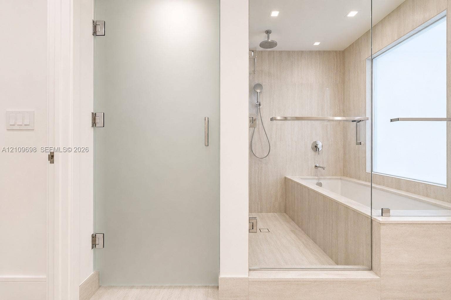 2411 Laguna Circle, #810, North Miami, FL 33181 Bathroom featuring a frosted glass door, tile-surround soaking tub, wall-mounted shower fixture, frameless glass partition, and recessed lighting