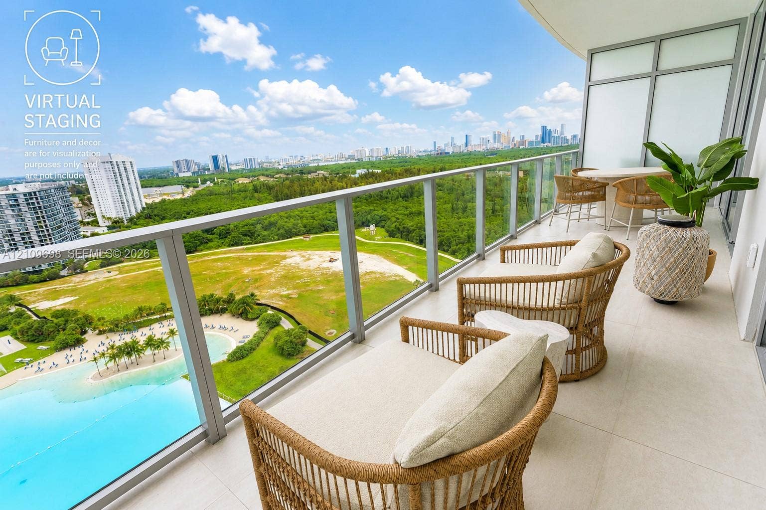 2411 Laguna Circle, #810, North Miami, FL 33181 Private covered balcony featuring large-format tile flooring and a glass-paneled railing overlooking an expansive landscape and skyline