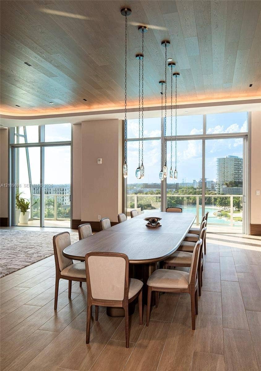 2411 Laguna Circle, #810, North Miami, FL 33181 Floor-to-ceiling windows, wood-finish flooring, recessed perimeter ceiling lighting, and suspended glass pendant lighting