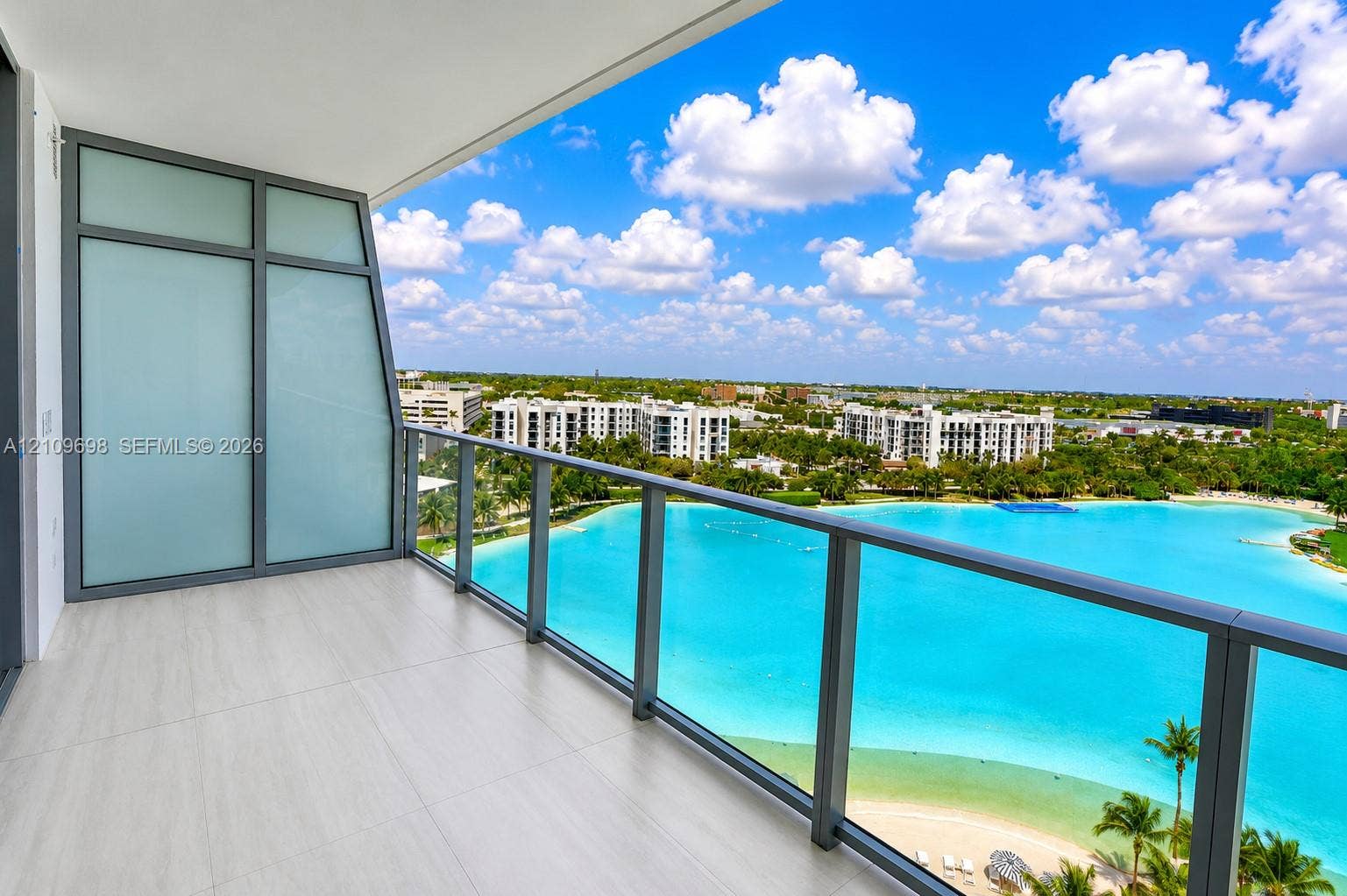 2411 Laguna Circle, #810, North Miami, FL 33181 Private balcony featuring large-format tile flooring, a glass panel railing, and translucent privacy screening