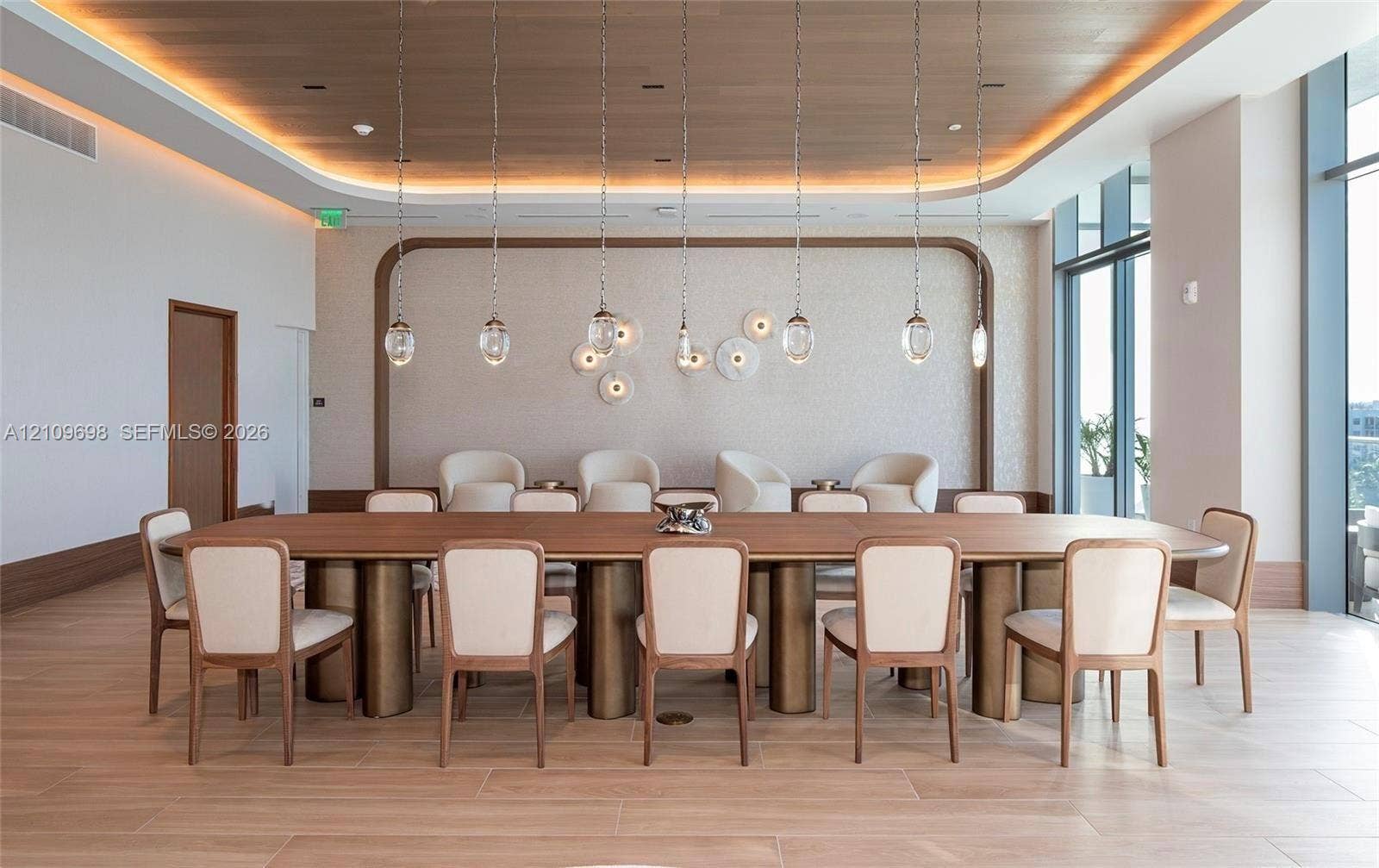 2411 Laguna Circle, #810, North Miami, FL 33181 Wood-finish flooring, recessed ceiling with perimeter accent lighting, wood-paneled ceiling inlay, a series of glass pendant light fixtures, and floor-to-ceiling windows