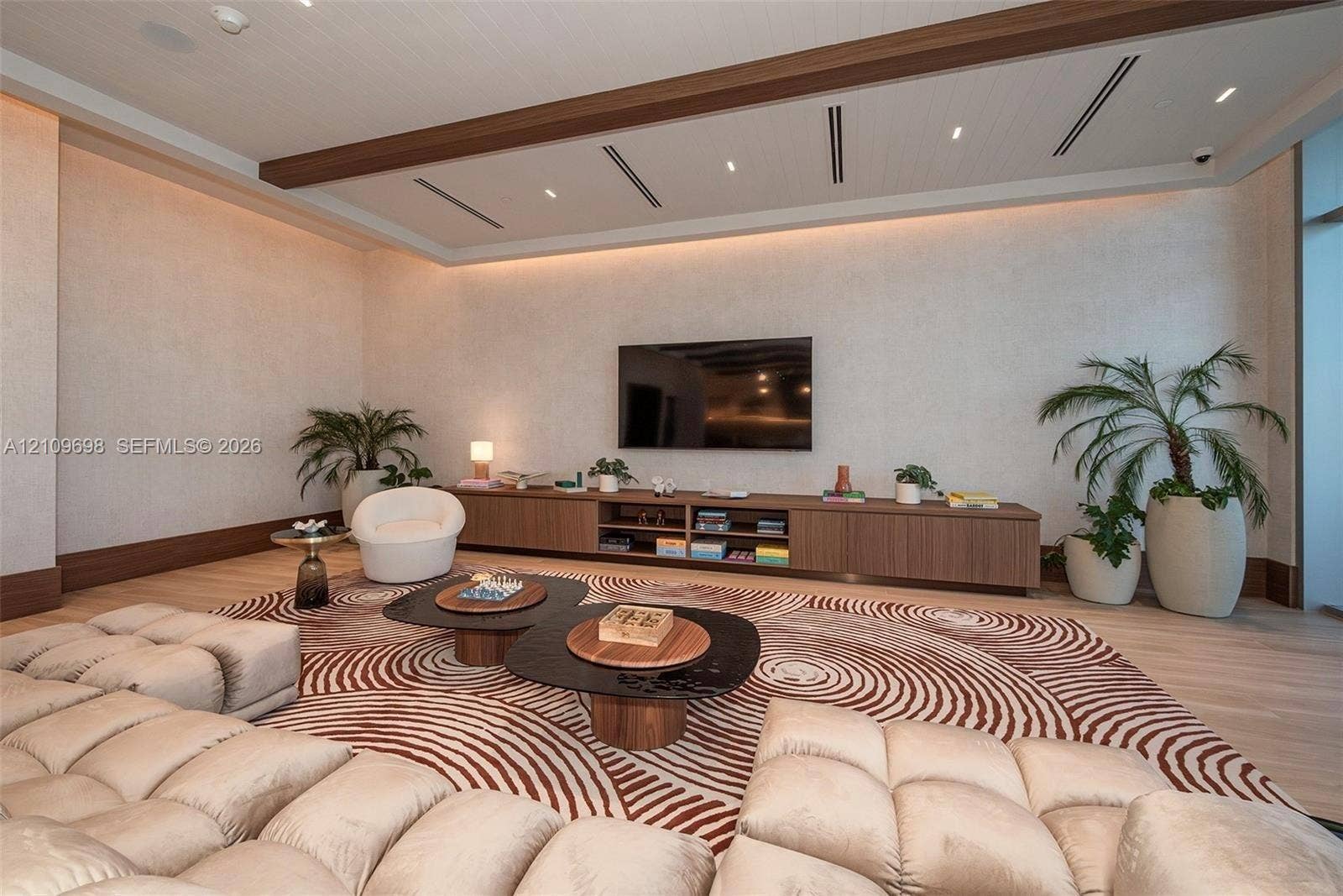 2411 Laguna Circle, #810, North Miami, FL 33181 Tray ceiling with recessed wood-trim detailing, linear lighting, integrated cabinetry with wood finish, and wood-finish flooring