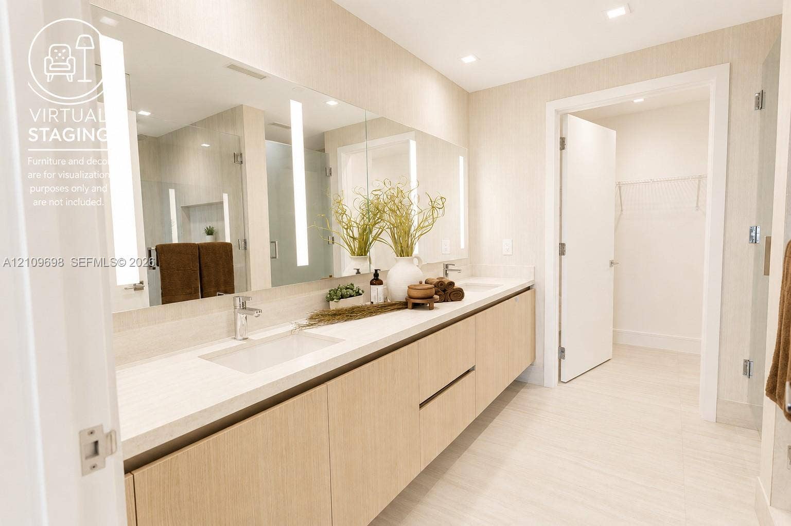 2411 Laguna Circle, #810, North Miami, FL 33181 Full-width vanity featuring light wood-finish cabinetry, dual undermount sinks, solid-surface countertops, recessed lighting, and wall-mounted vertical vanity mirrors with integrated illumination