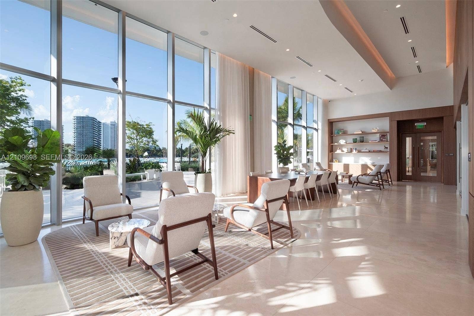 2411 Laguna Circle, #810, North Miami, FL 33181 Floor-to-ceiling windows, high ceilings with recessed lighting, stone flooring, and built-in wood shelving