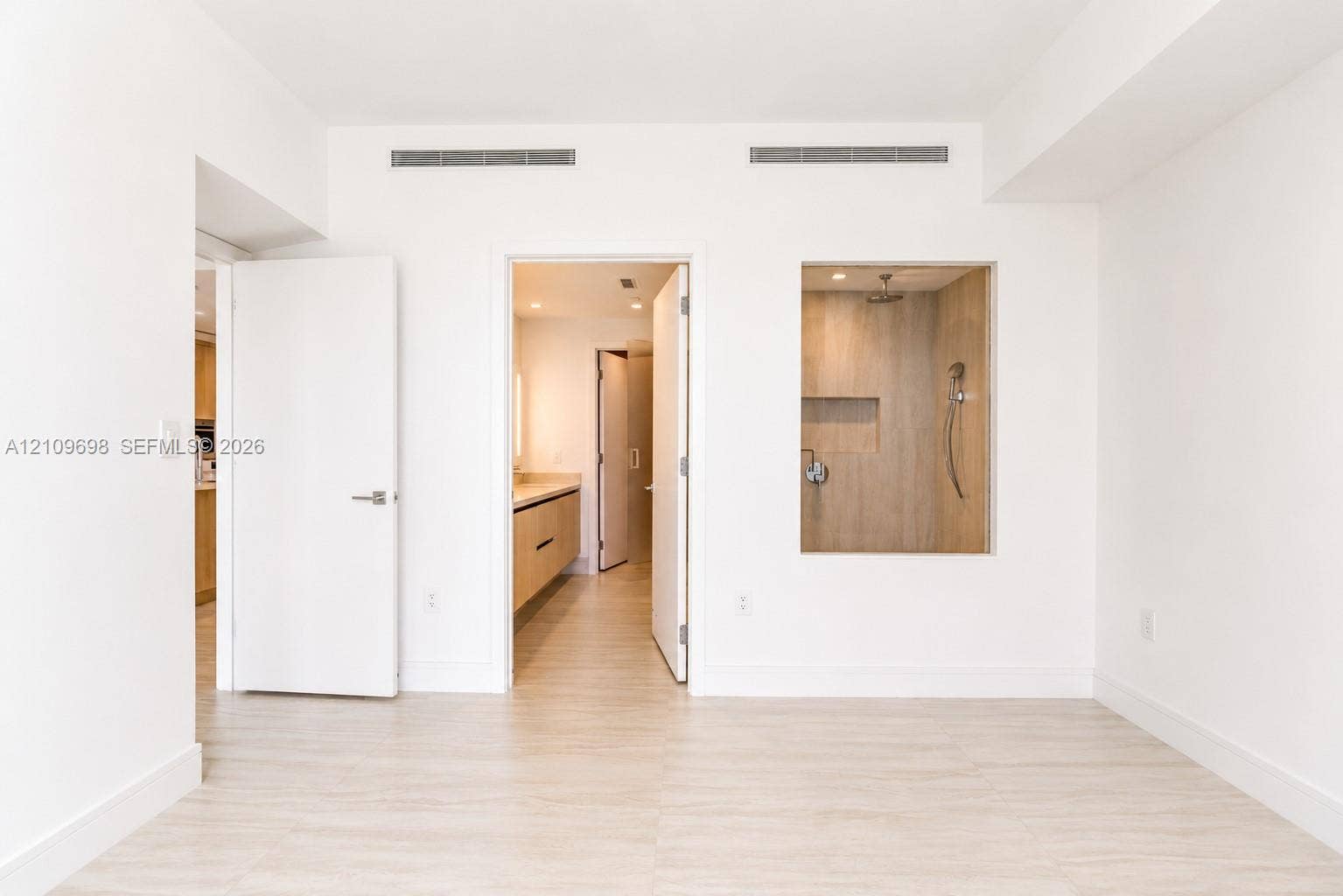 2411 Laguna Circle, #810, North Miami, FL 33181 Interior space featuring wood-finish flooring, a recessed shower enclosure with wood-finish wall tile, a built-in recessed shower niche, and a wall-mounted shower fixture