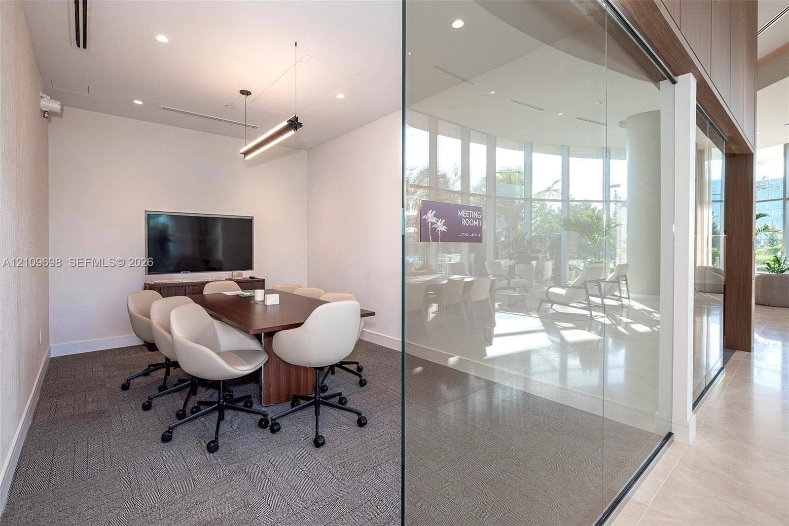 2411 Laguna Circle, #810, North Miami, FL 33181 Meeting room featuring floor-to-ceiling glass wall, recessed lighting, linear pendant light fixture, and neutral carpeted flooring