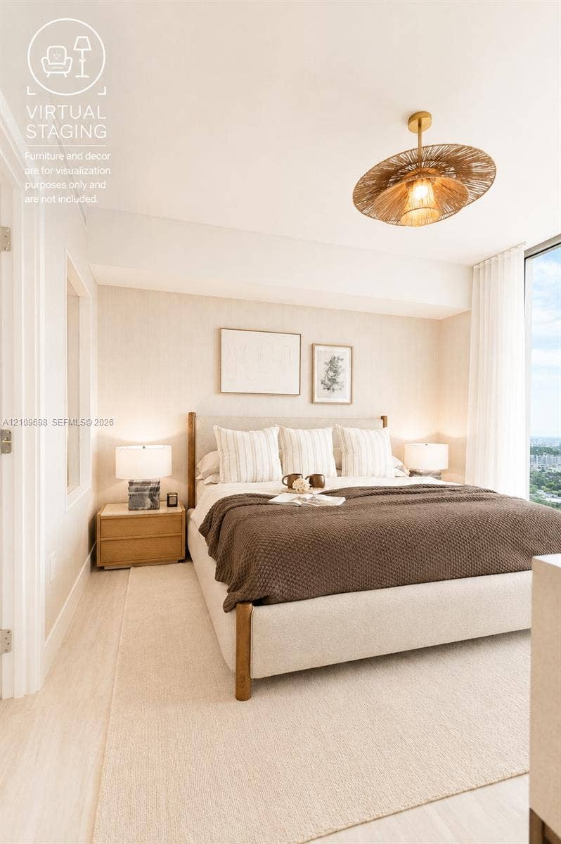2411 Laguna Circle, #810, North Miami, FL 33181 Room featuring expansive floor-to-ceiling windows, light-toned wood-finish flooring, and a textured woven drum pendant light