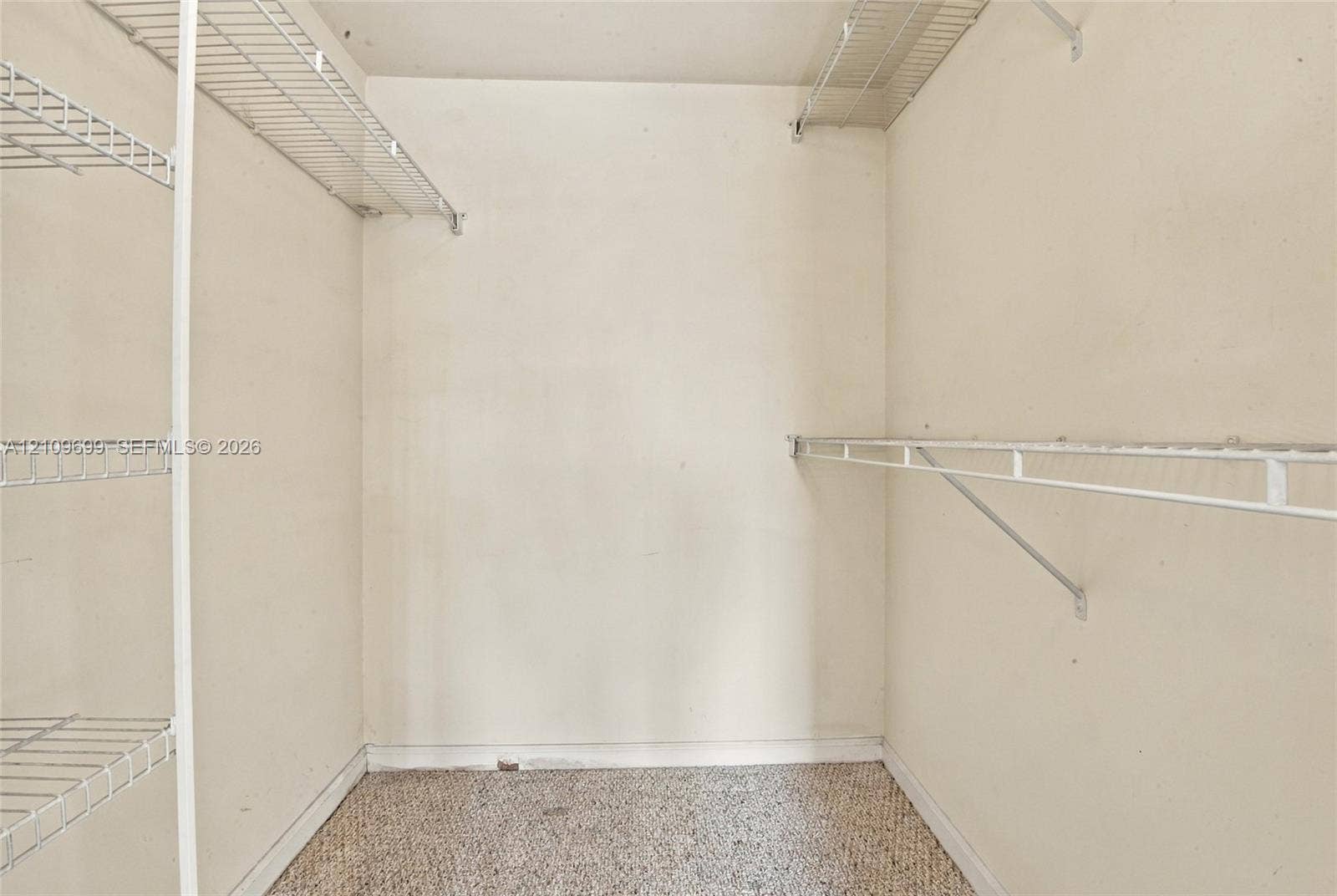Storage space featuring white wall-mounted wire shelving units