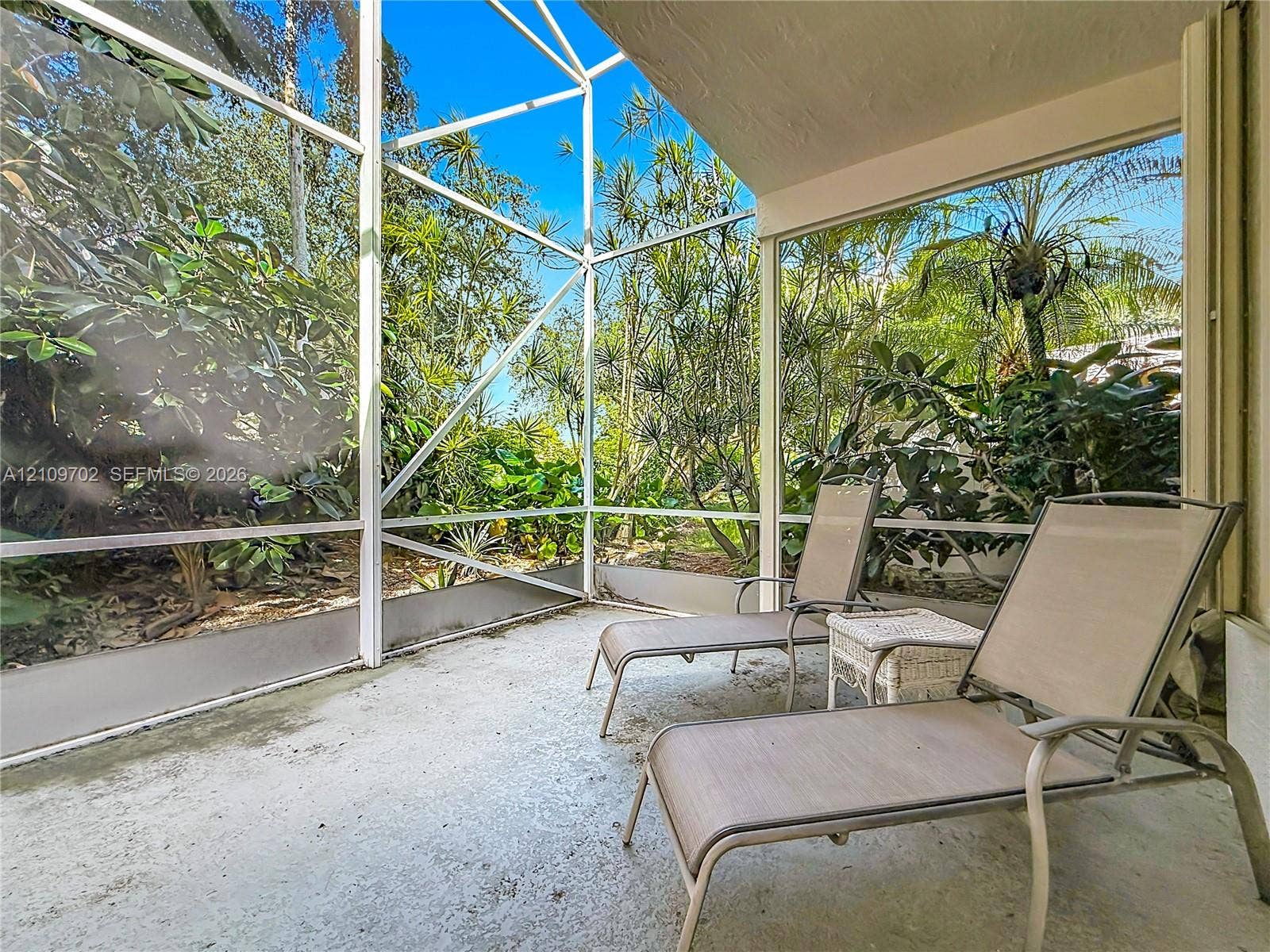 Screened-in lanai featuring a concrete floor and aluminum framing