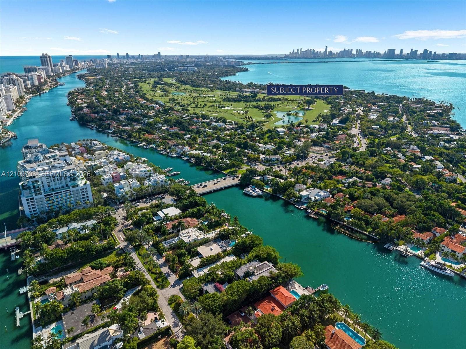 421 W 62nd Street, Miami Beach, FL 33140 Aerial perspective of a coastal residential area featuring deep-water canal access, proximity to a golf course, and a backdrop of open bay waters
