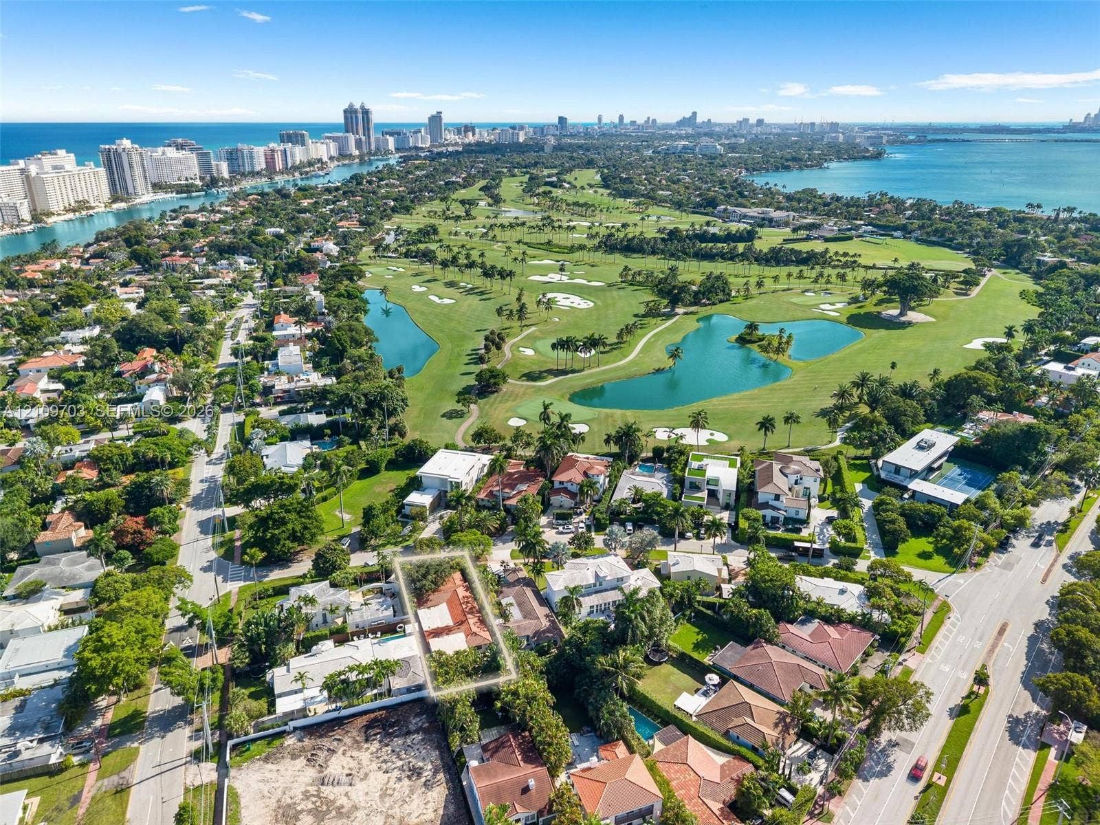 421 W 62nd Street, Miami Beach, FL 33140 Aerial perspective of a property lot featuring mature landscaping and a tiled roof structure, positioned within a coastal metropolitan landscape
