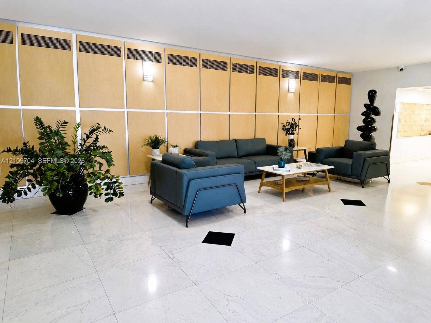 6770 Indian Creek Drive, #14C, Miami Beach, FL 33141 Large-scale wood paneling, polished stone flooring, integrated wall-mounted lighting, and structural square floor accents