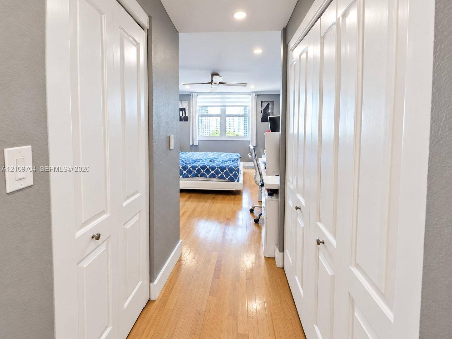 6770 Indian Creek Drive, #14C, Miami Beach, FL 33141 Hallway featuring wood-finish flooring, recessed lighting, and dual sets of white bi-fold closet doors