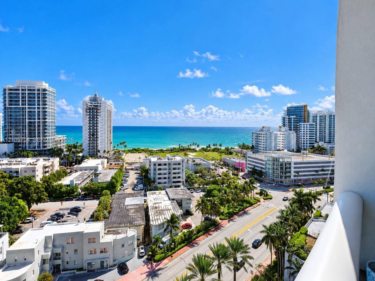 6770 Indian Creek Drive, #14C, Miami Beach, FL 33141 Elevated balcony featuring a white railing and expansive coastal scenery including ocean, sandy shoreline, and metropolitan architecture