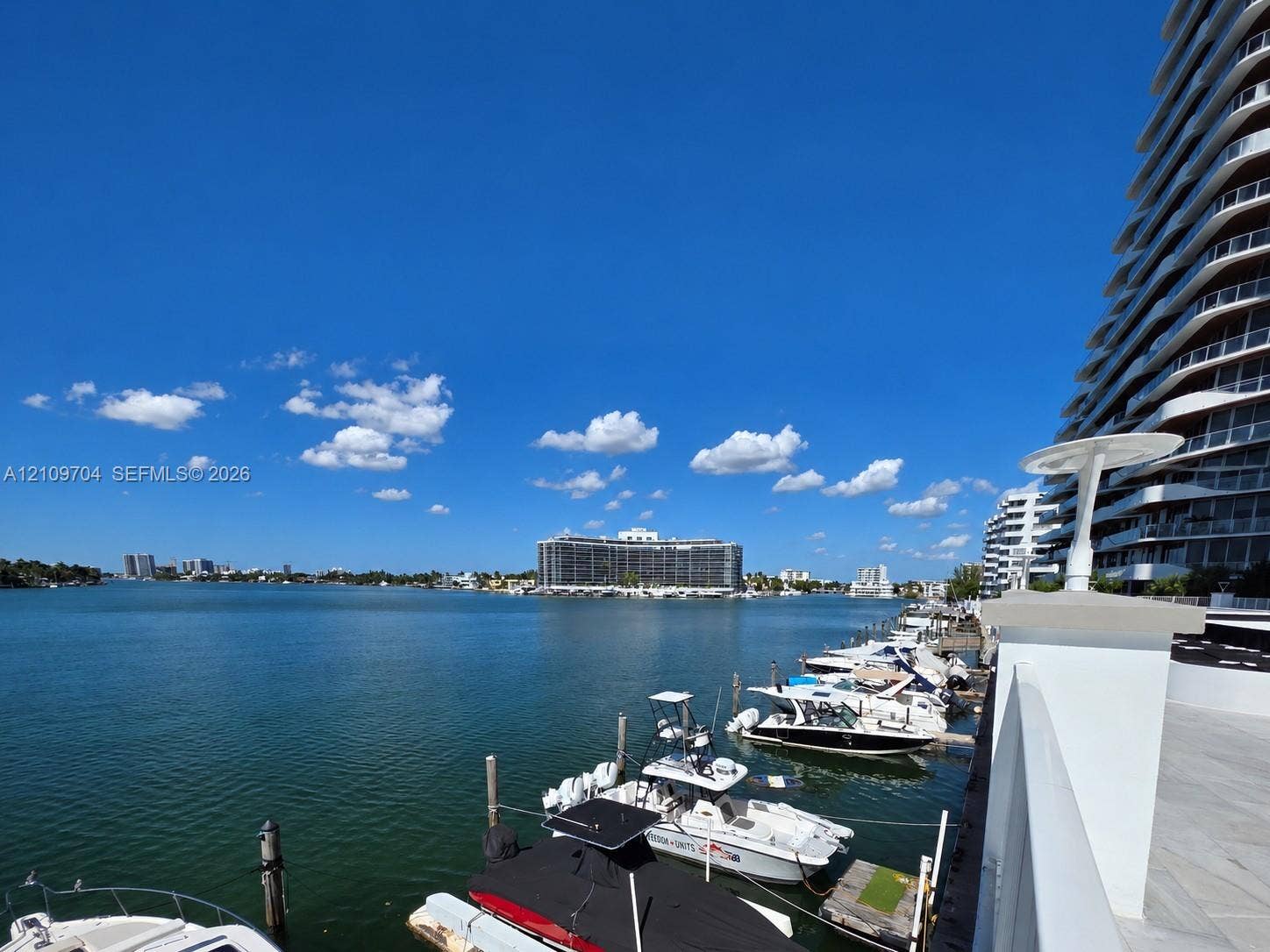 6770 Indian Creek Drive, #14C, Miami Beach, FL 33141 Waterfront property featuring a private boat slip, dockside power pedestals, concrete seawall, and stone-finished decking