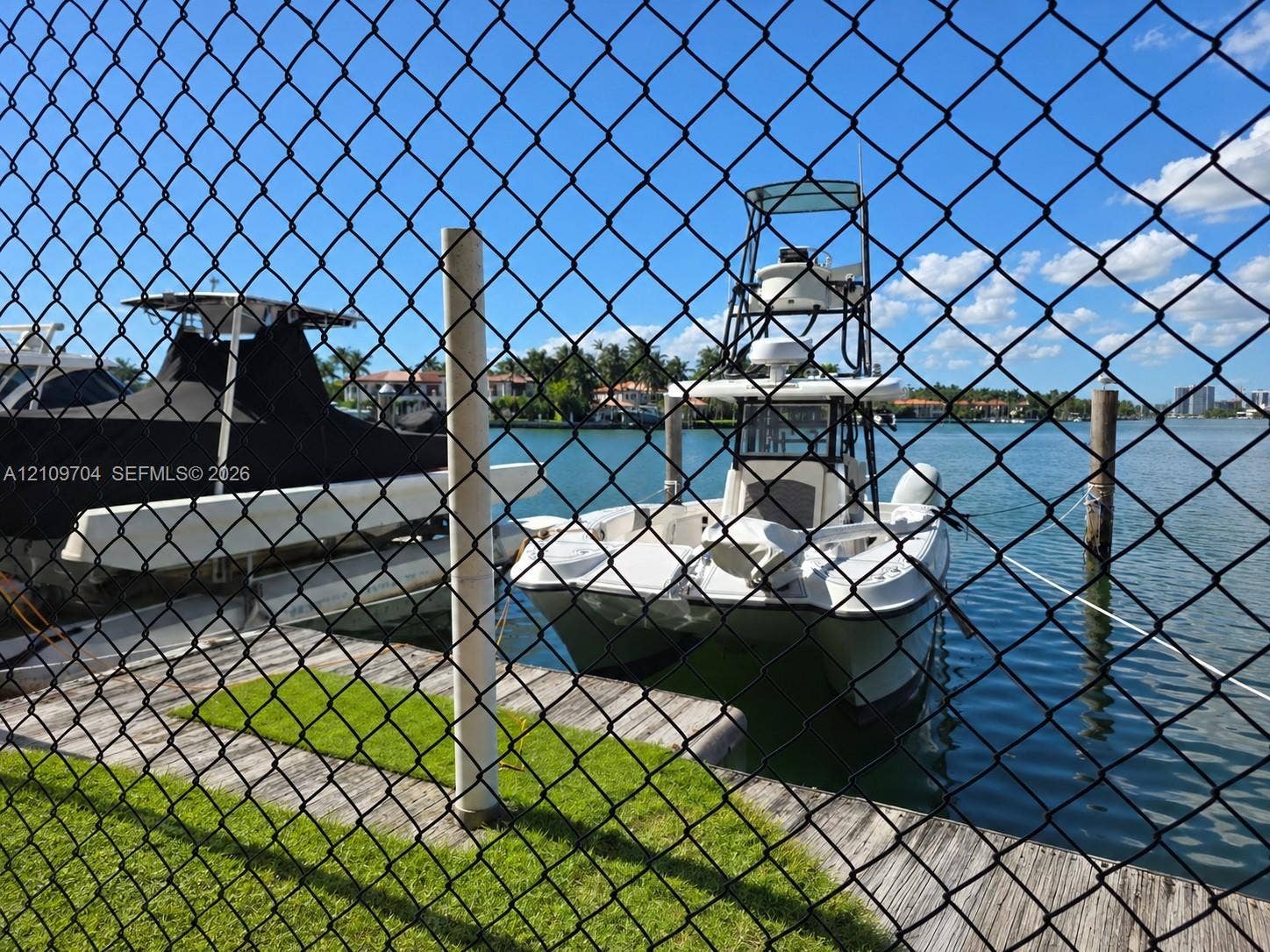 6770 Indian Creek Drive, #14C, Miami Beach, FL 33141 Waterfront property featuring a wooden bulkhead, piling moorings, and direct access to an expansive canal