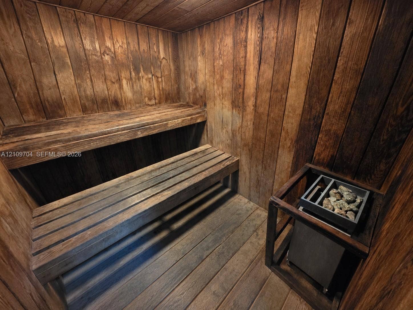 6770 Indian Creek Drive, #14C, Miami Beach, FL 33141 Custom sauna featuring tongue-and-groove wood paneling, multi-level slatted wood benches, and a built-in electric rock heater
