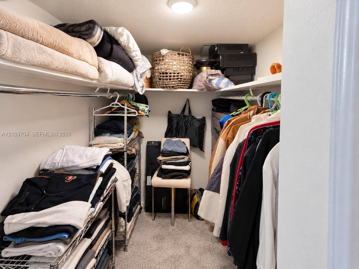 6770 Indian Creek Drive, #14C, Miami Beach, FL 33141 Walk-in storage space featuring wrap-around shelving, a metal hanging rod, and ceiling-mounted lighting