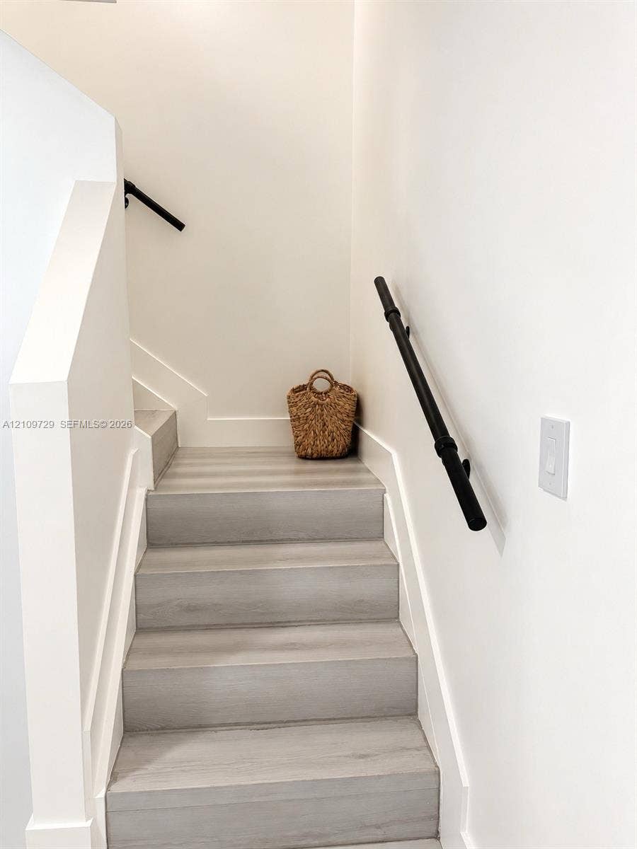 12665 SW 54th Court, Miramar, FL 33027 Staircase featuring wood-finish treads and matte black wall-mounted handrails