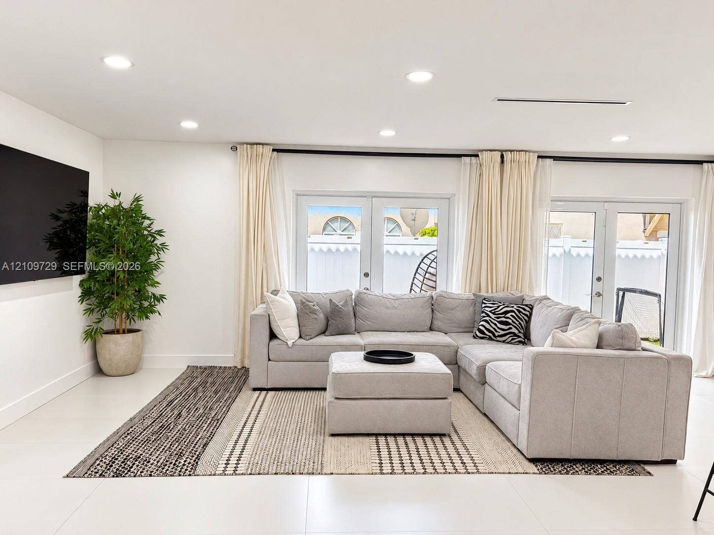 12665 SW 54th Court, Miramar, FL 33027 Open-concept space featuring recessed lighting, large-format tile flooring, and dual glass-panel patio doors