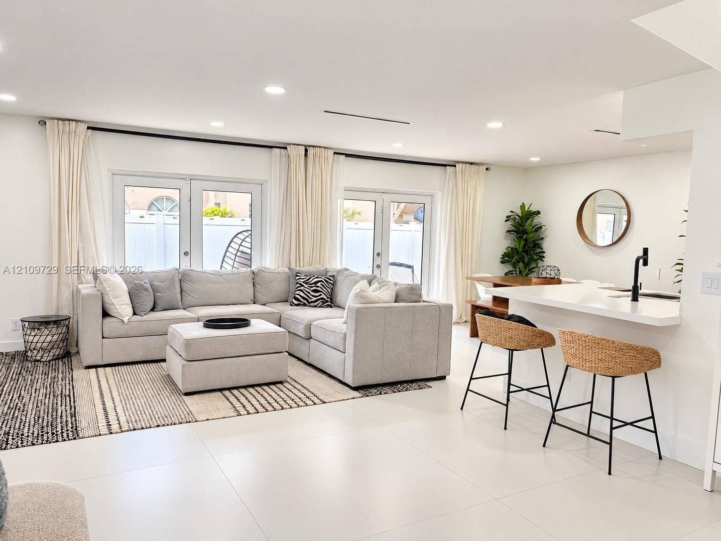 12665 SW 54th Court, Miramar, FL 33027 Open-concept interior featuring large-format tile flooring, recessed lighting, and dual sets of French doors