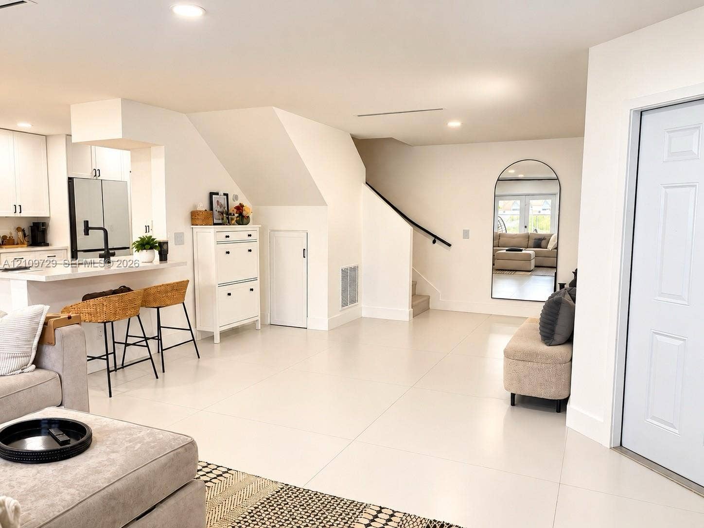 12665 SW 54th Court, Miramar, FL 33027 Open interior featuring large-format tile flooring, recessed lighting, kitchen with peninsula, and stairway with a matte black handrail