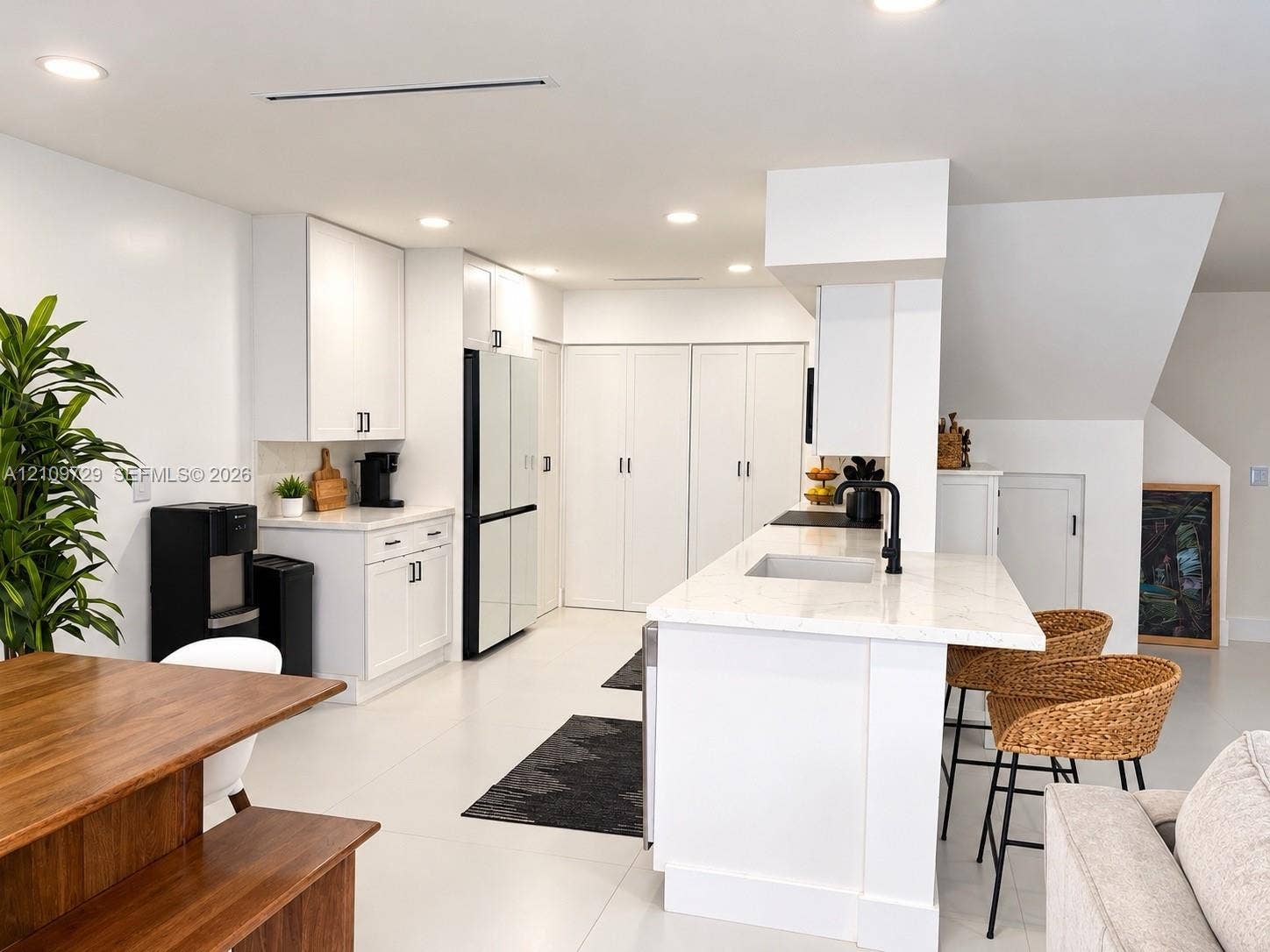 12665 SW 54th Court, Miramar, FL 33027 Kitchen featuring white shaker-style cabinetry, quartz countertops, a central island with a built-in sink, matte black hardware, and recessed ceiling lighting