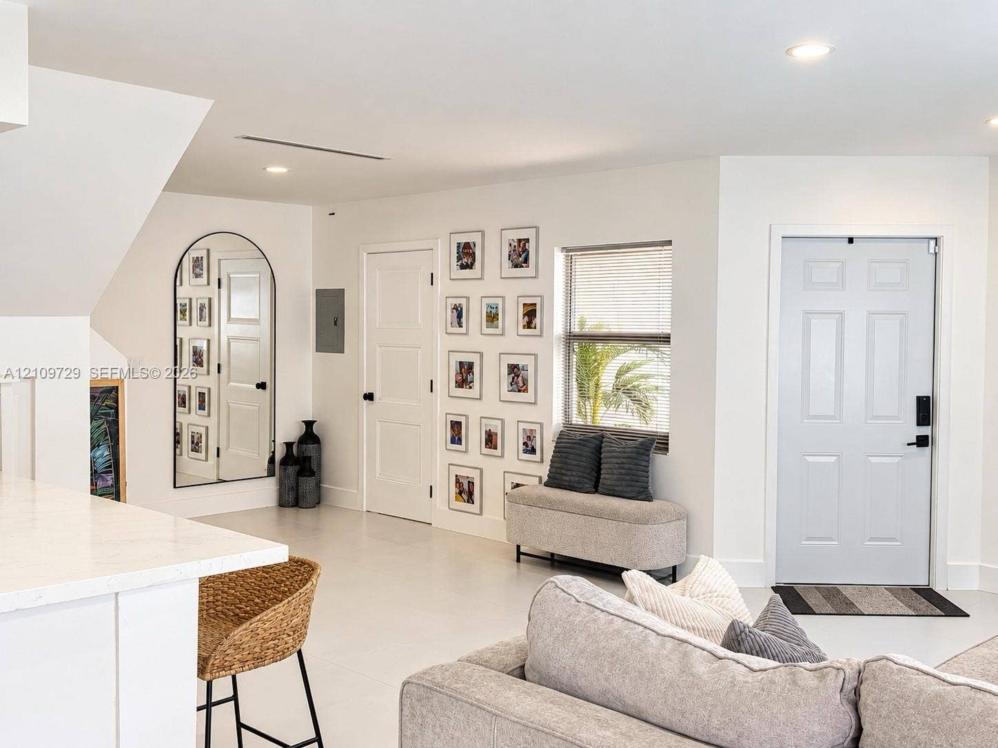12665 SW 54th Court, Miramar, FL 33027 Interior space featuring neutral tile flooring, recessed ceiling lighting, a six-panel entry door with smart lock technology, and an arched-frame mirror