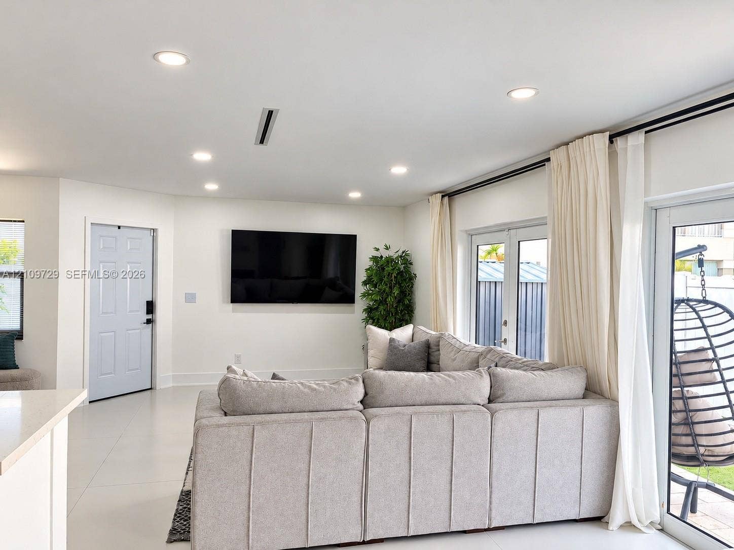 12665 SW 54th Court, Miramar, FL 33027 Open-concept interior featuring large-format tile flooring, recessed lighting, and double-glass paneled doors providing exterior access