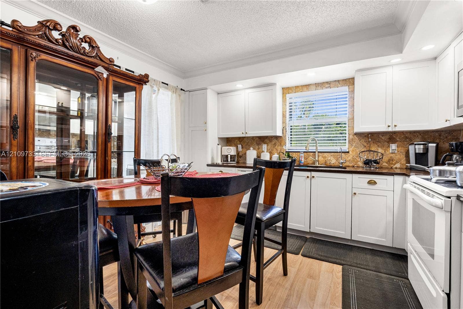 Kitchen featuring white cabinetry, stone-texture backsplash, recessed lighting, and wood-finish flooring