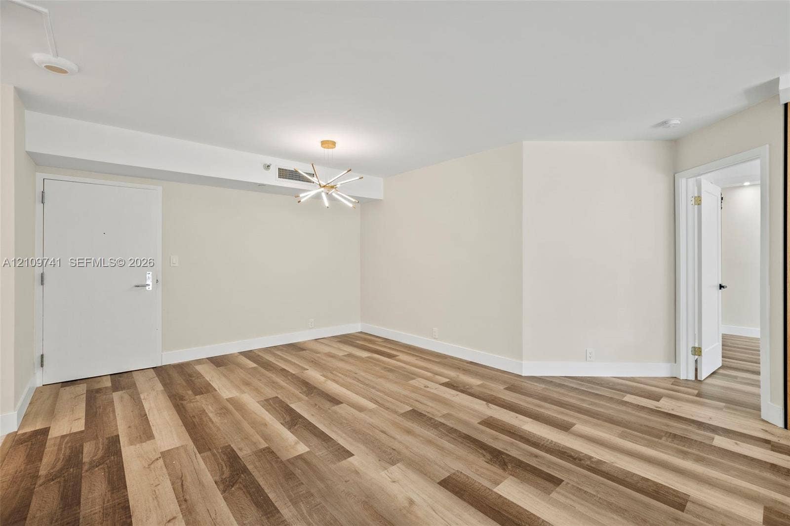 19101 NE 36th Court, #203, Aventura, FL 33180 Interior space featuring wood-finish flooring, a modern multi-arm starburst chandelier, and smooth-finish walls