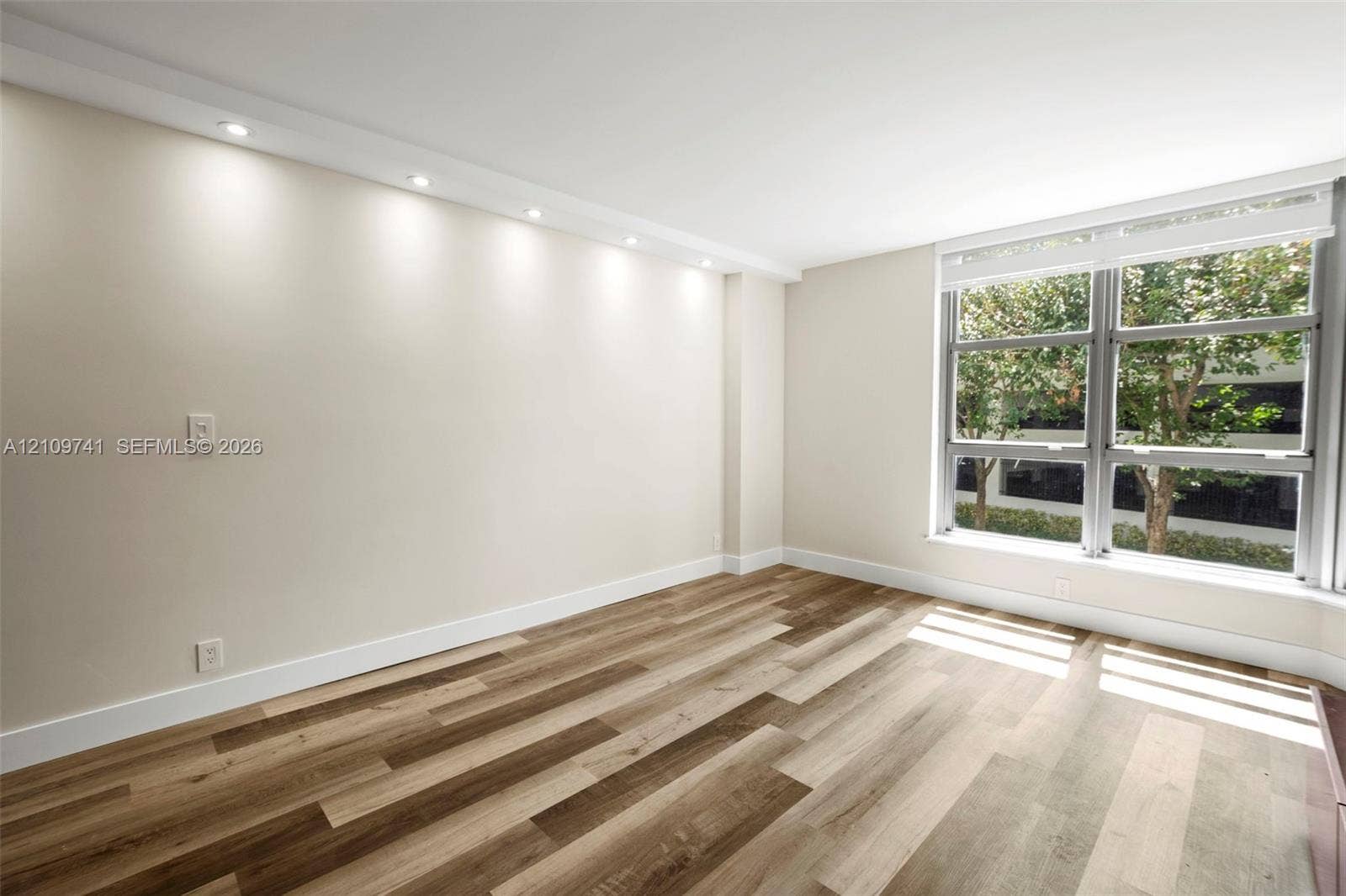 19101 NE 36th Court, #203, Aventura, FL 33180 Room featuring wood-finish flooring, recessed ceiling lighting, and large windows with integrated blinds