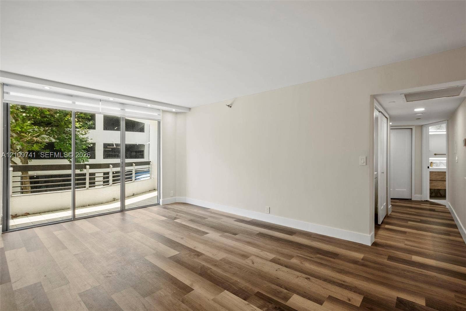19101 NE 36th Court, #203, Aventura, FL 33180 Wood-finish flooring, full-height sliding glass doors, and recessed ceiling lighting