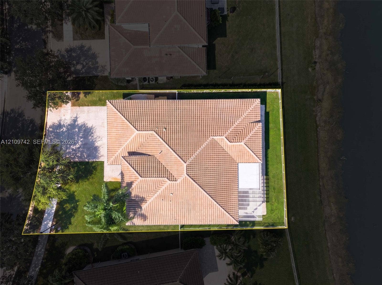 19143 SW 60th Court, Pembroke Pines, FL 33332 Aerial perspective of a property featuring a tile roof, concrete driveway, and a fenced yard with perimeter landscaping