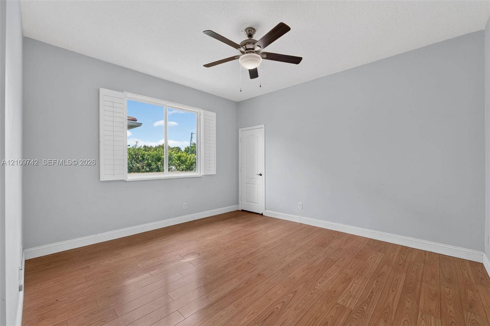 19143 SW 60th Court, Pembroke Pines, FL 33332 Room featuring wood-finish flooring, plantation shutters, and a central ceiling fan with an integrated light fixture