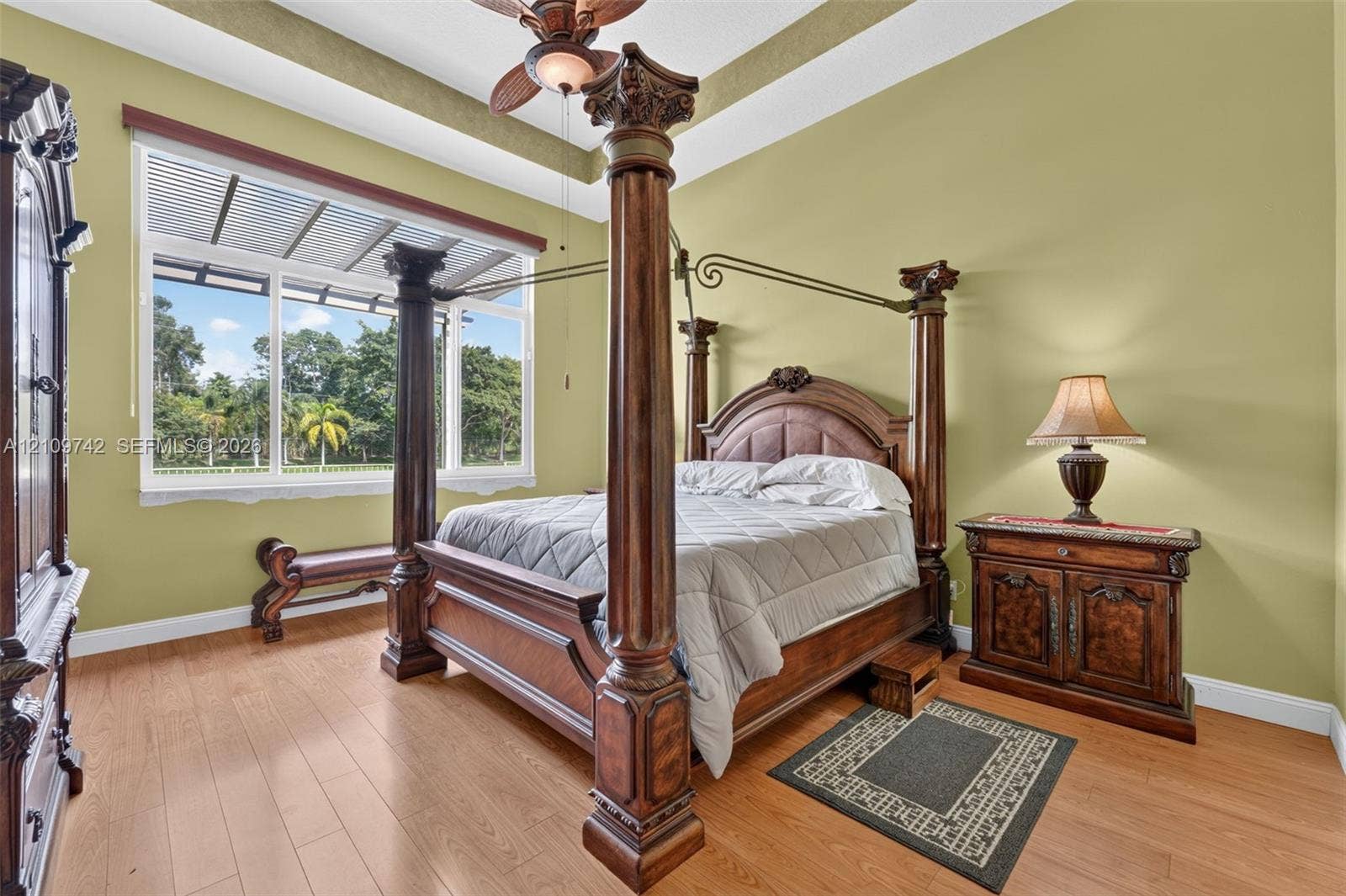 19143 SW 60th Court, Pembroke Pines, FL 33332 Tray ceiling with crown molding, wood-finish flooring, and large window with exterior landscape backdrop