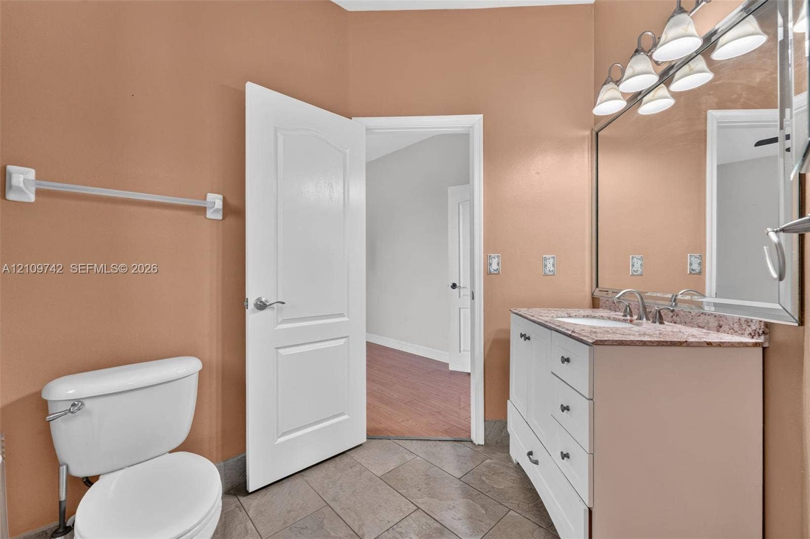 19143 SW 60th Court, Pembroke Pines, FL 33332 White vanity cabinet with stone-finish countertop, undermount sink, multi-light fixture, and ceramic tile flooring