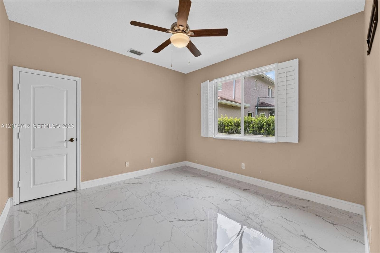 19143 SW 60th Court, Pembroke Pines, FL 33332 Large-format tile flooring with a veined pattern, multi-panel interior door, and a ceiling-mounted fan with integrated lighting