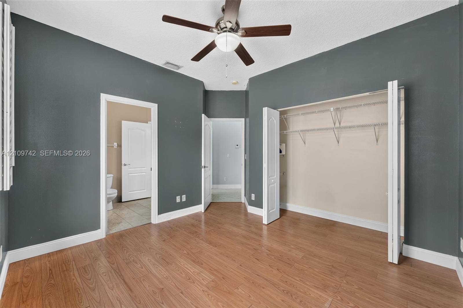 19143 SW 60th Court, Pembroke Pines, FL 33332 Interior space featuring wood-finish flooring, a ceiling fan with integrated lighting, and a reach-in closet with built-in wire shelving