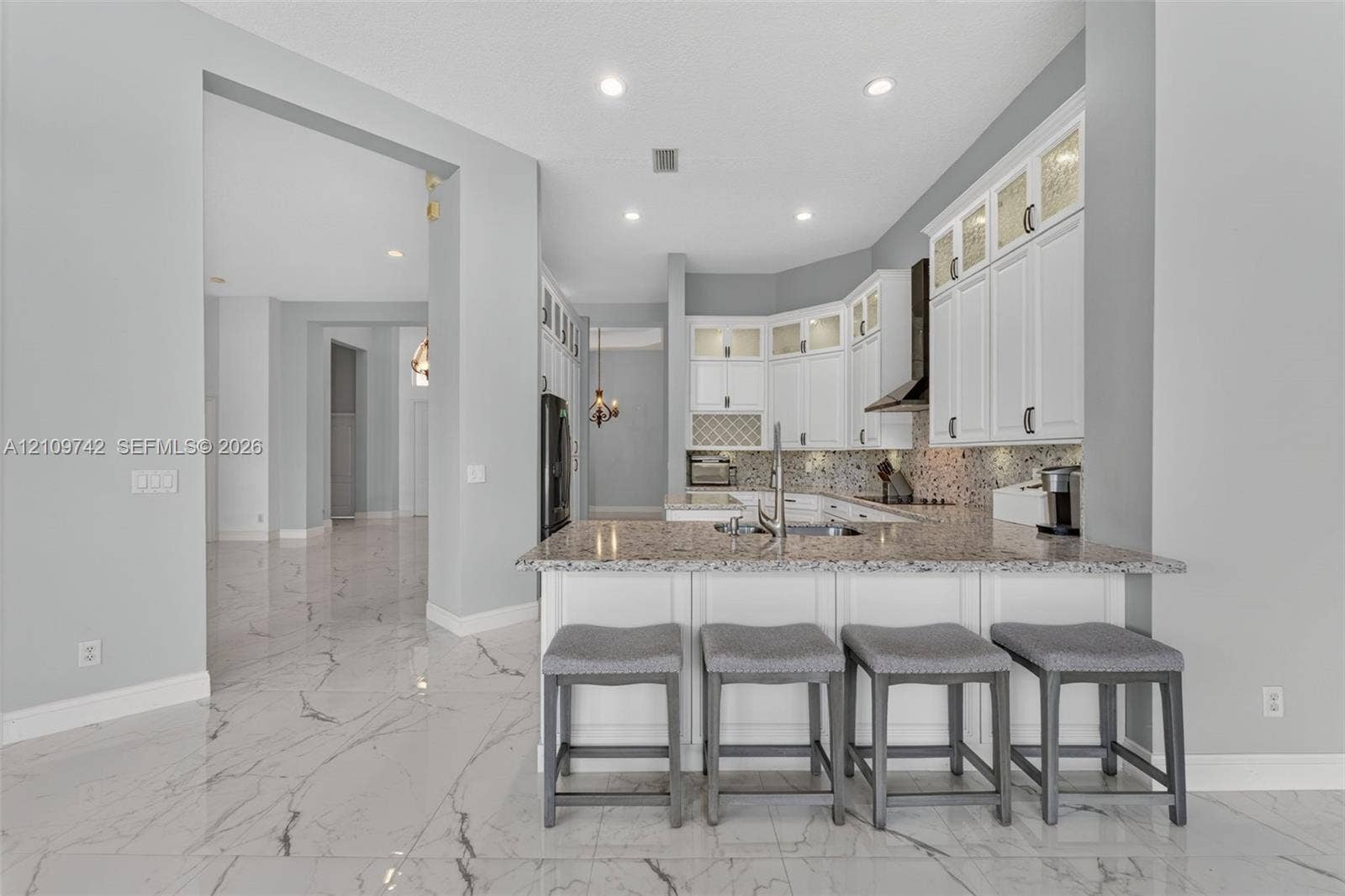 19143 SW 60th Court, Pembroke Pines, FL 33332 Kitchen featuring white cabinetry with glass-front uppers, stone-patterned countertops, a stainless steel undermount sink, recessed ceiling lighting, and large-format polished tile flooring