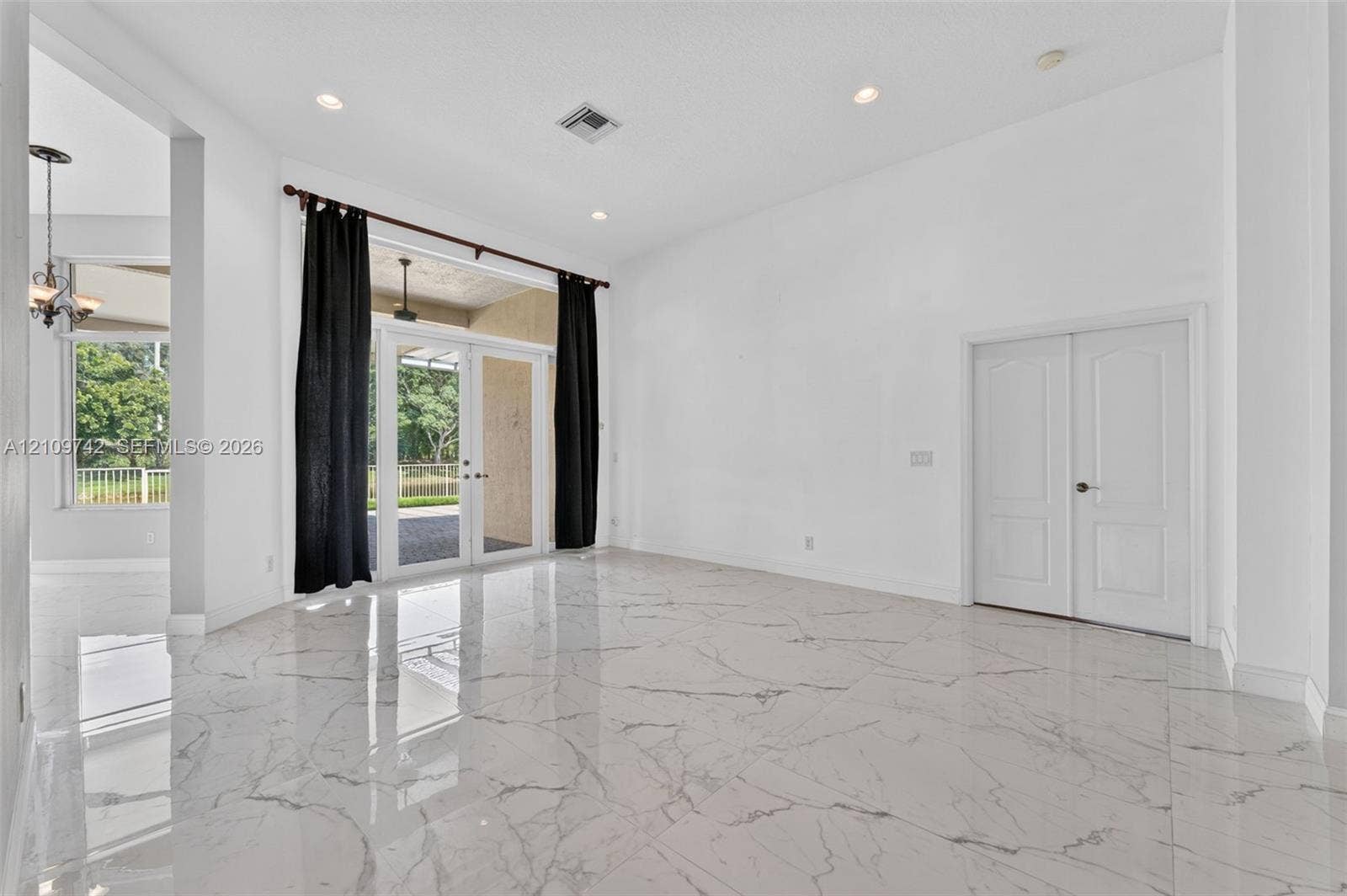 19143 SW 60th Court, Pembroke Pines, FL 33332 High-ceiling interior featuring polished stone-finish tile flooring, recessed lighting, double French doors, and a double-door entry