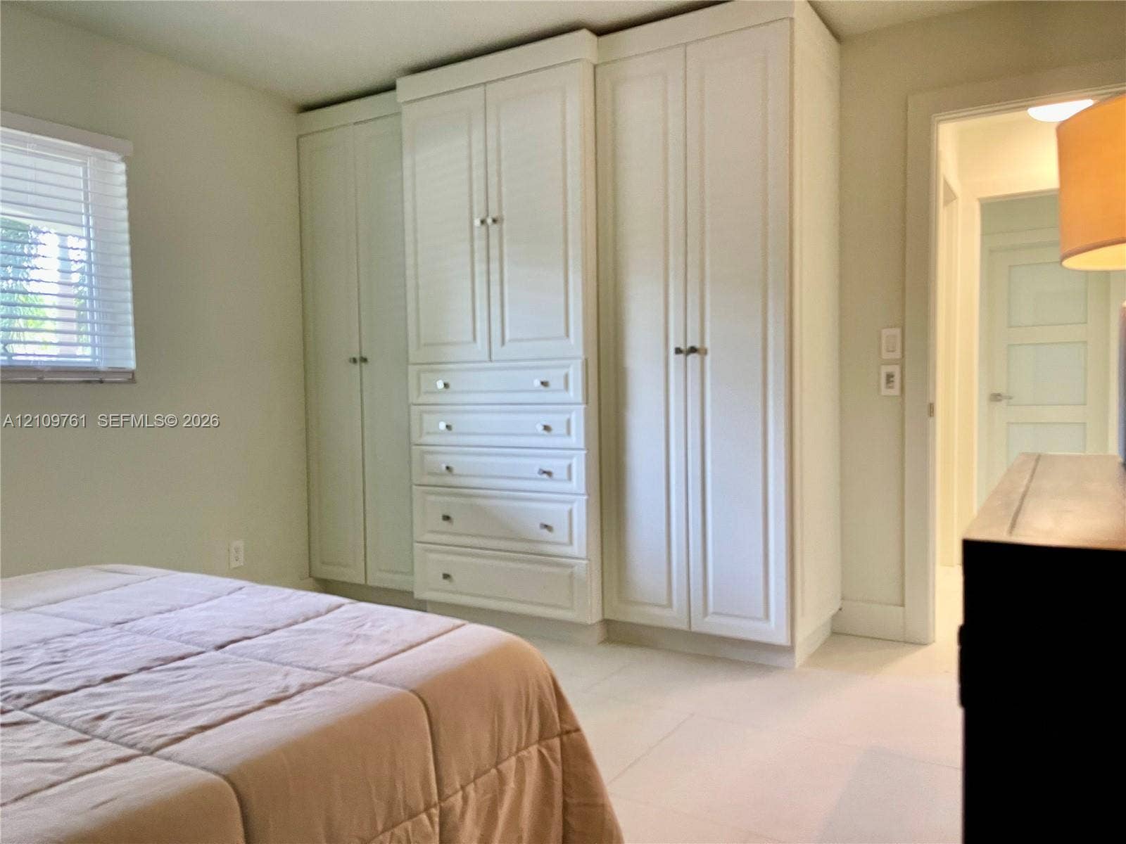 Custom built-in white cabinetry featuring shaker-style doors, integrated storage drawers, and brushed metal hardware