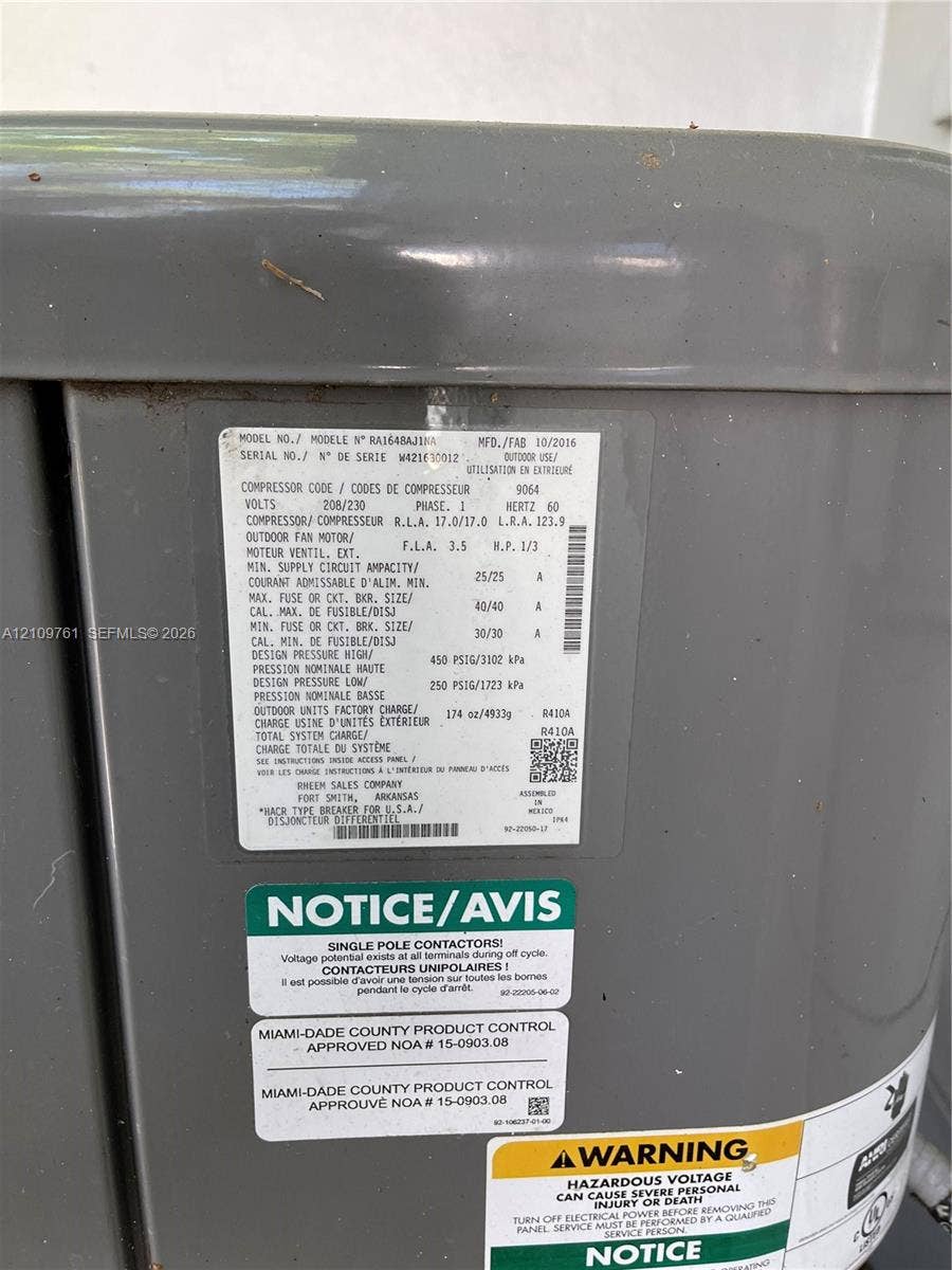 Outdoor heating and cooling unit featuring a durable grey enamel finish, factory-specified technical data plate, and Miami-Dade County product control certification