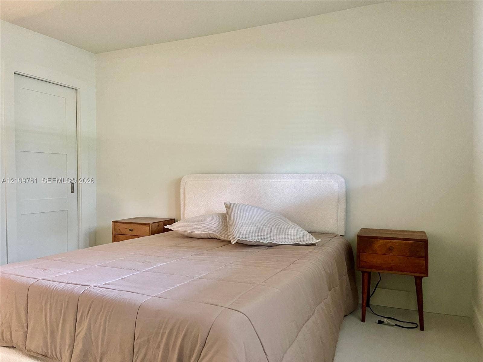 Neutral interior space featuring smooth wall surfaces, a single-panel interior door, and clean finishes