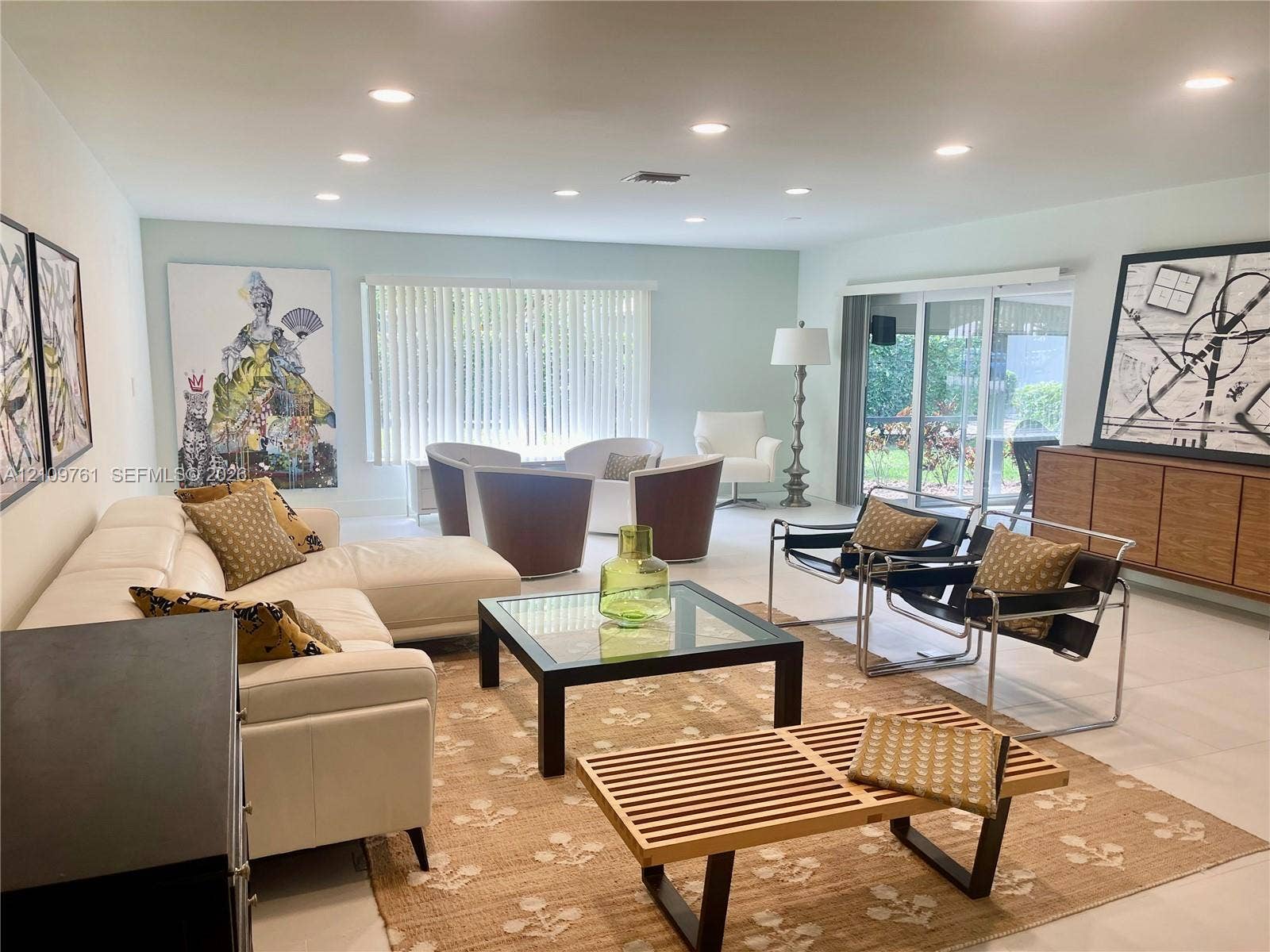Open-concept living space featuring neutral tile flooring, recessed lighting, and sliding glass doors