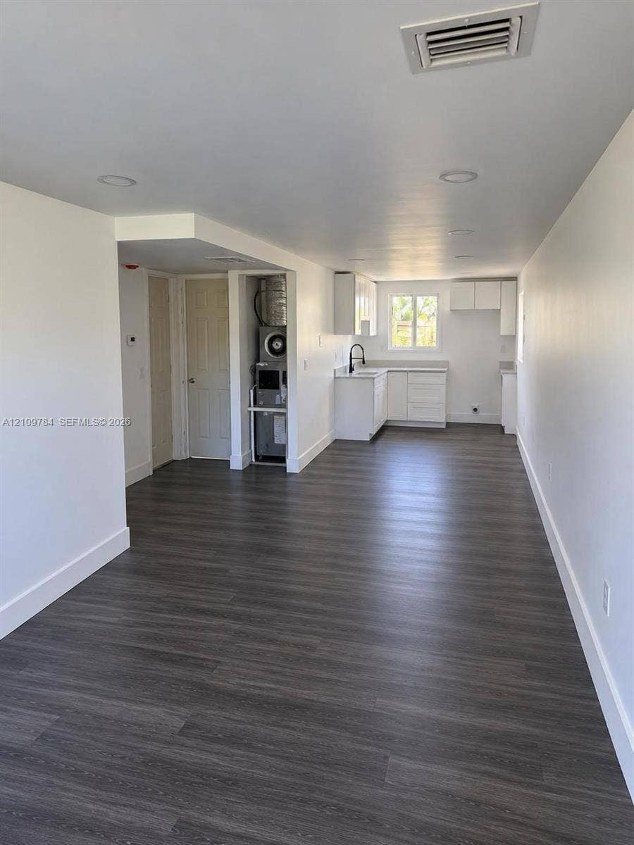 Interior space featuring wood-finish flooring, recessed lighting, and white cabinetry
